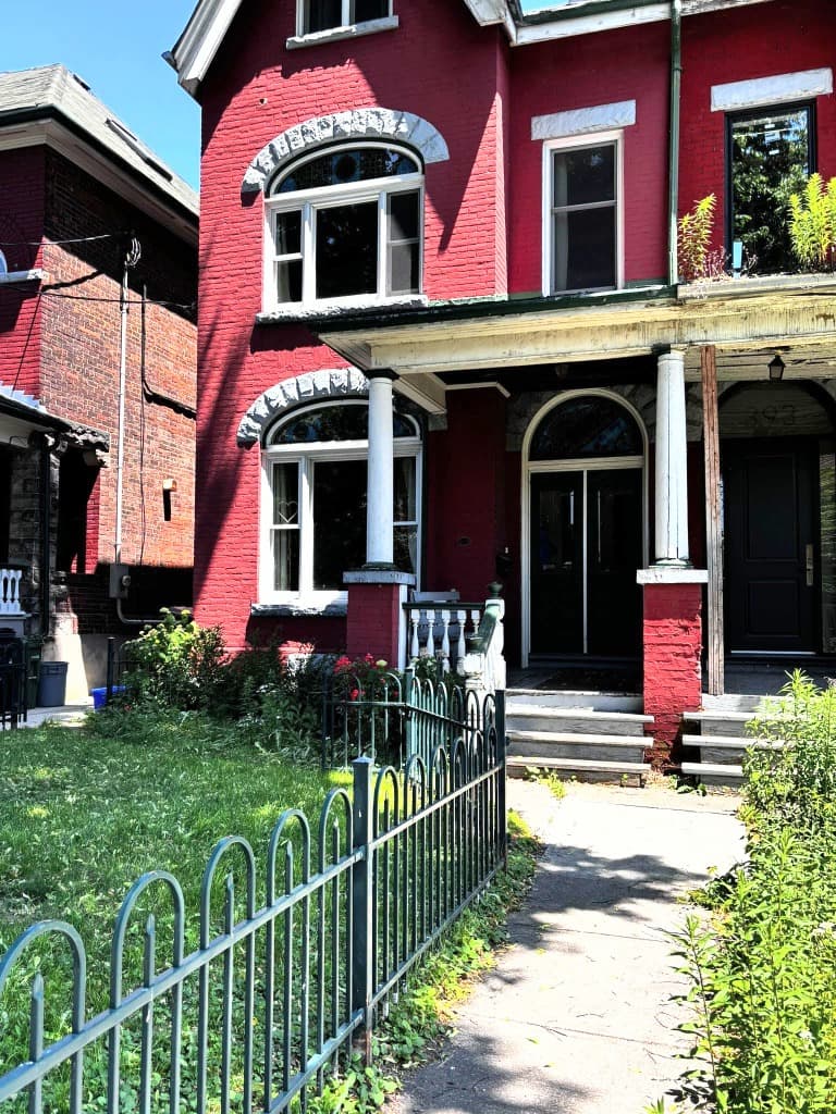 Close-up view of the entrance to 393 Manning Ave showing ornate stonework and Victorian architectural details