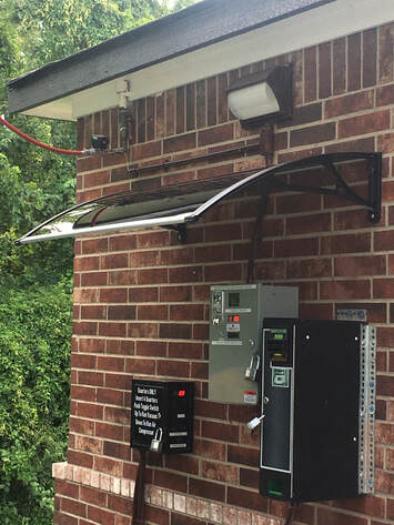 Side view of coin box installation under overhang showing protection from elements