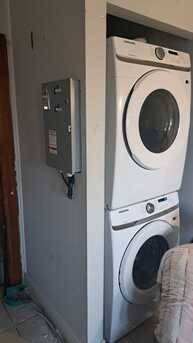Wall inset coin converter installation next to stacked washer and dryer